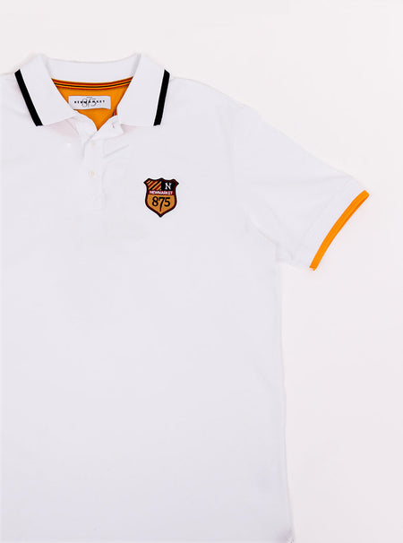 Flat lay of men's white polo shirt in 100% cotton with Newmarket 875 crest embroidered on the front and giant red 8 on the back with navy sleeve trimming and gold collar trimming.